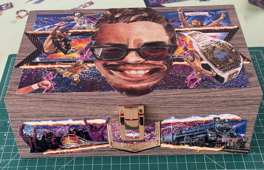 A custom wooden box with a vibrant, colorful collage of WWE wrestling, dogs, cats, and trains, honoring an individual's passions.