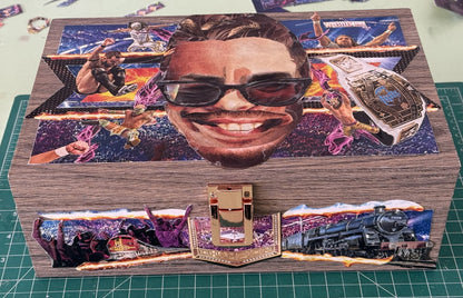 A custom wooden box with a vibrant, colorful collage of WWE wrestling, dogs, cats, and trains, honoring an individual's passions.
